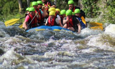 people in green life vest on water during daytime